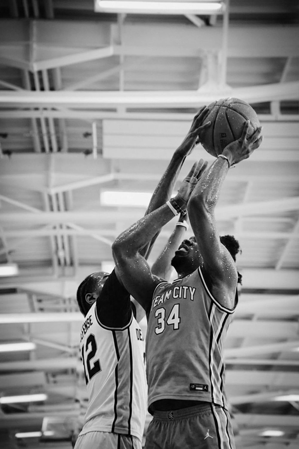 Deux basketteurs à la lutte pour un rebond